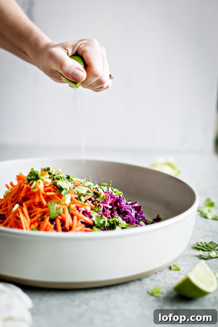 Crispy Black Bean Tacos with Cilantro-Lime Slaw 6 photo of woman squeezing lime into a bowl of cilantro lime slaw