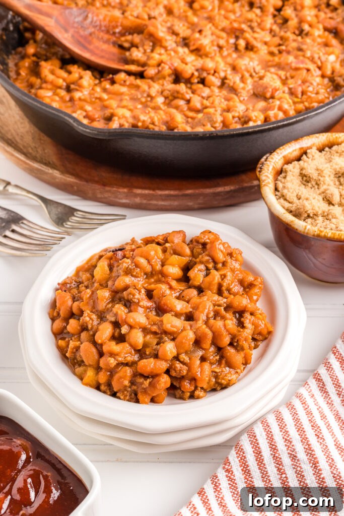Hearty Baked Beans with Ground Beef — Stovetop, Oven or Slow Cooker 9 Baked beans in a white bowl.