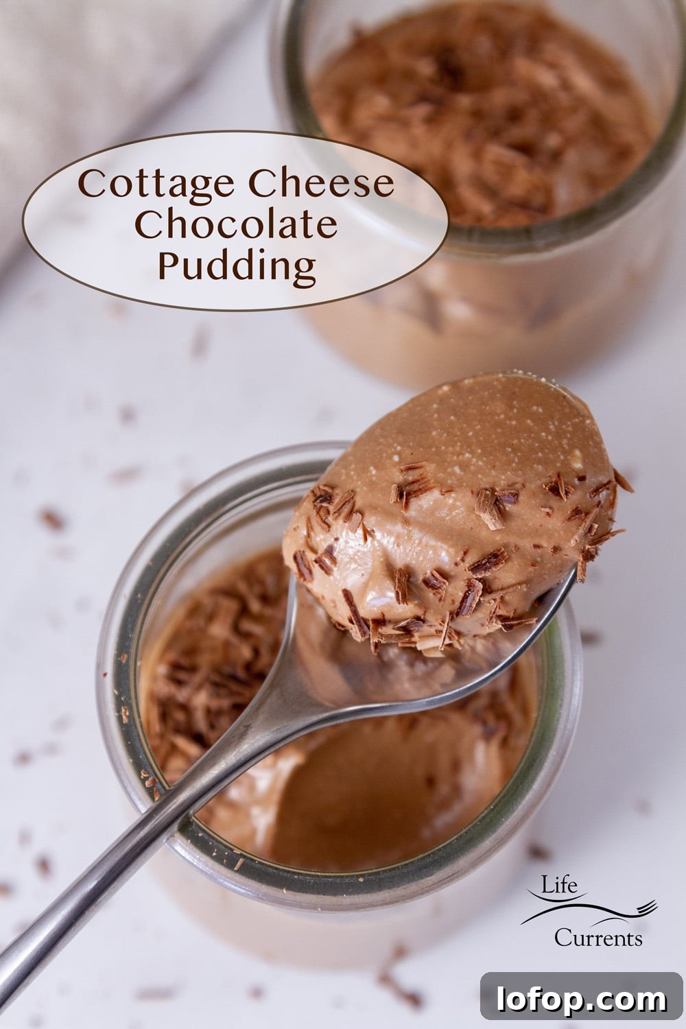 Creamy Cottage Cheese Chocolate Pudding Recipe 2 two servings of chocolate pudding in glass jars, one with a spoon with the pudding in it on top of the jar.