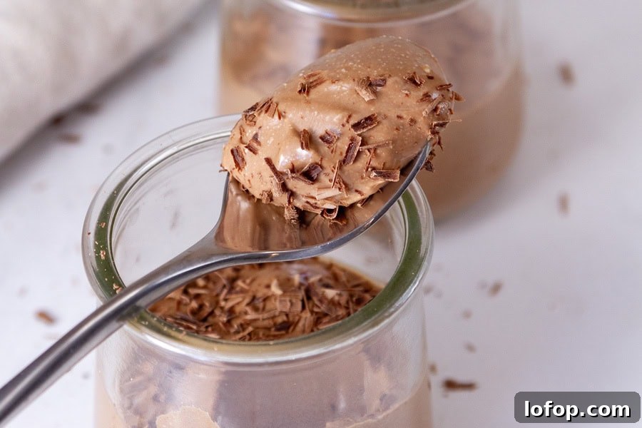Creamy Cottage Cheese Chocolate Pudding Recipe 12 a glass jar with chocolate pudding and a spoon on top has taken a bite out.