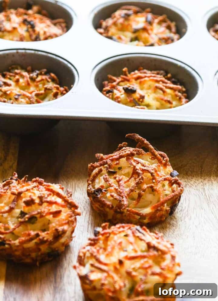 Three golden crispy edged hash browns baked in a muffin tin on cutting board.