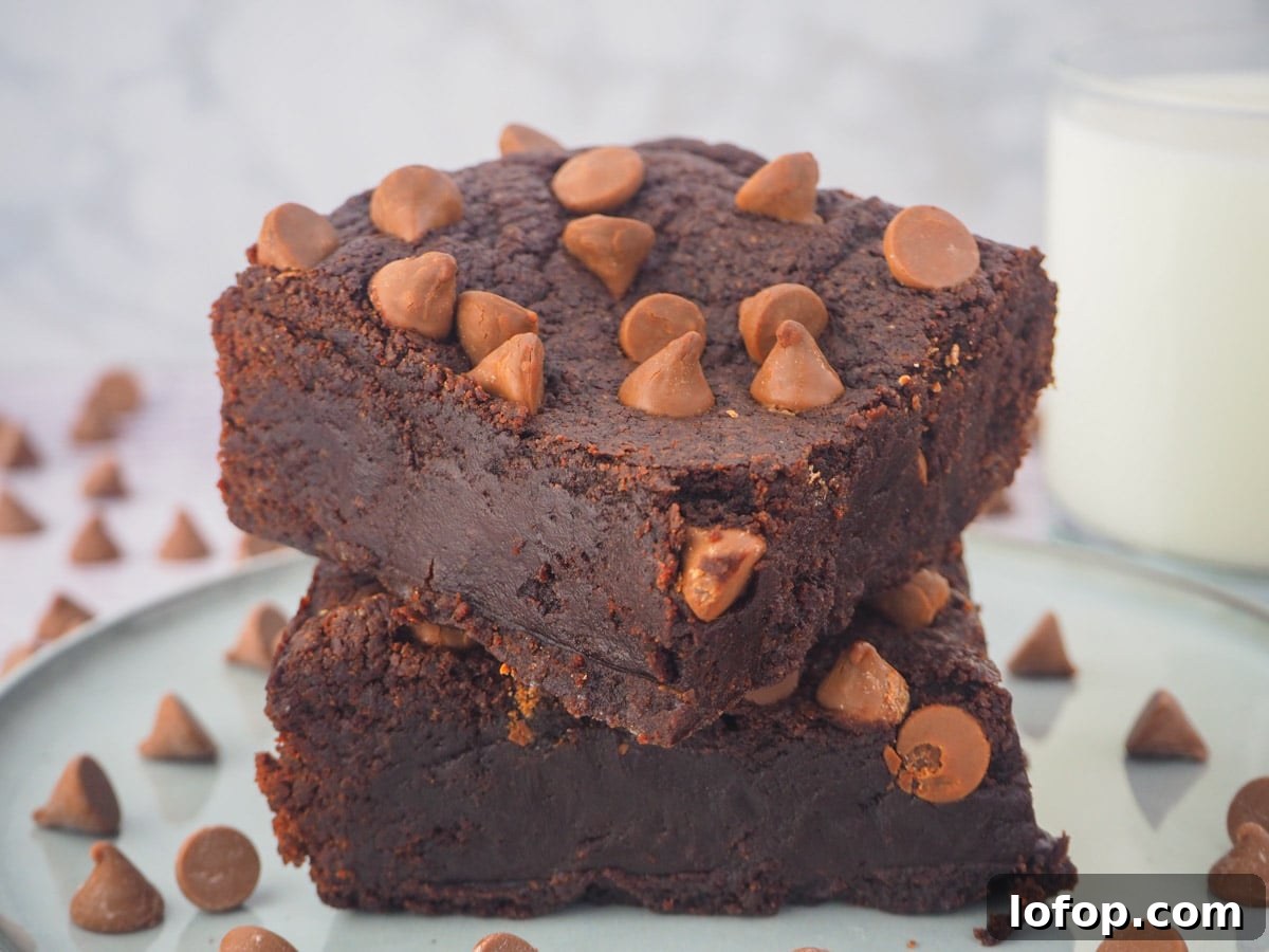 Decadent Egg-Free Brownies Recipe for Fudgy Chocolate Bliss 14 Stack of eggless brownies on a plate with a glass of milk in the background.