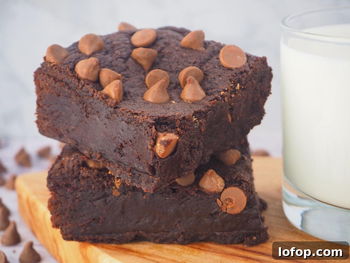 Decadent Egg-Free Brownies Recipe for Fudgy Chocolate Bliss 4 Stack of eggless brownies on a board with a glass of milk.
