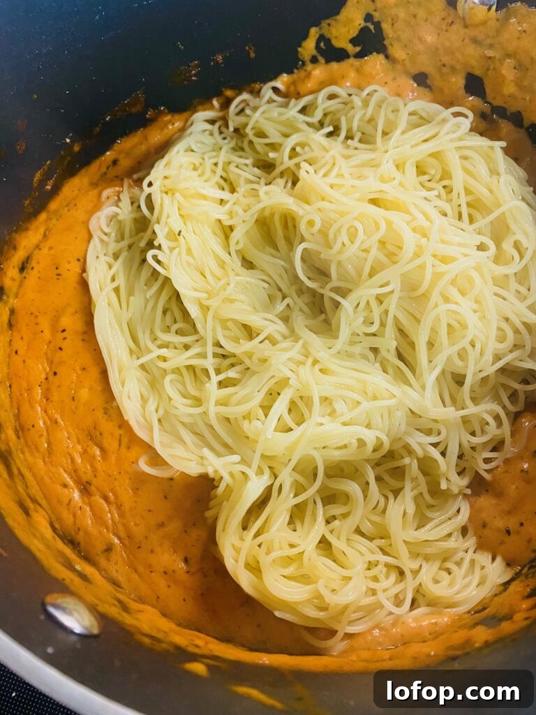 adding pasta to Pasta with Tomato Cream Sauce