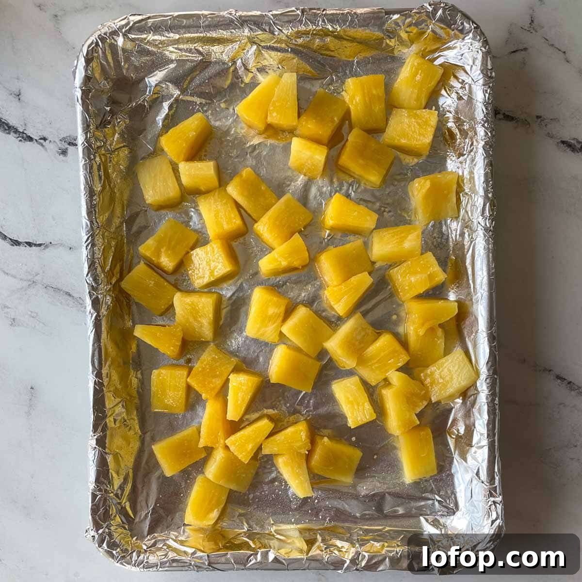 Tangy Pineapple Habanero Salsa Recipe for Grilling and Tacos 5 Pieces of pineapple sit on a sheet tray.