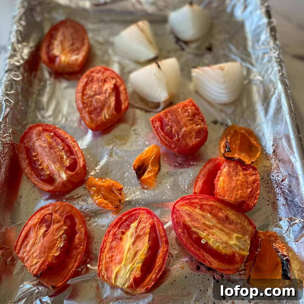 Tangy Pineapple Habanero Salsa Recipe for Grilling and Tacos 9 Roasted tomato, habanero, and onion are shown on a sheet tray.
