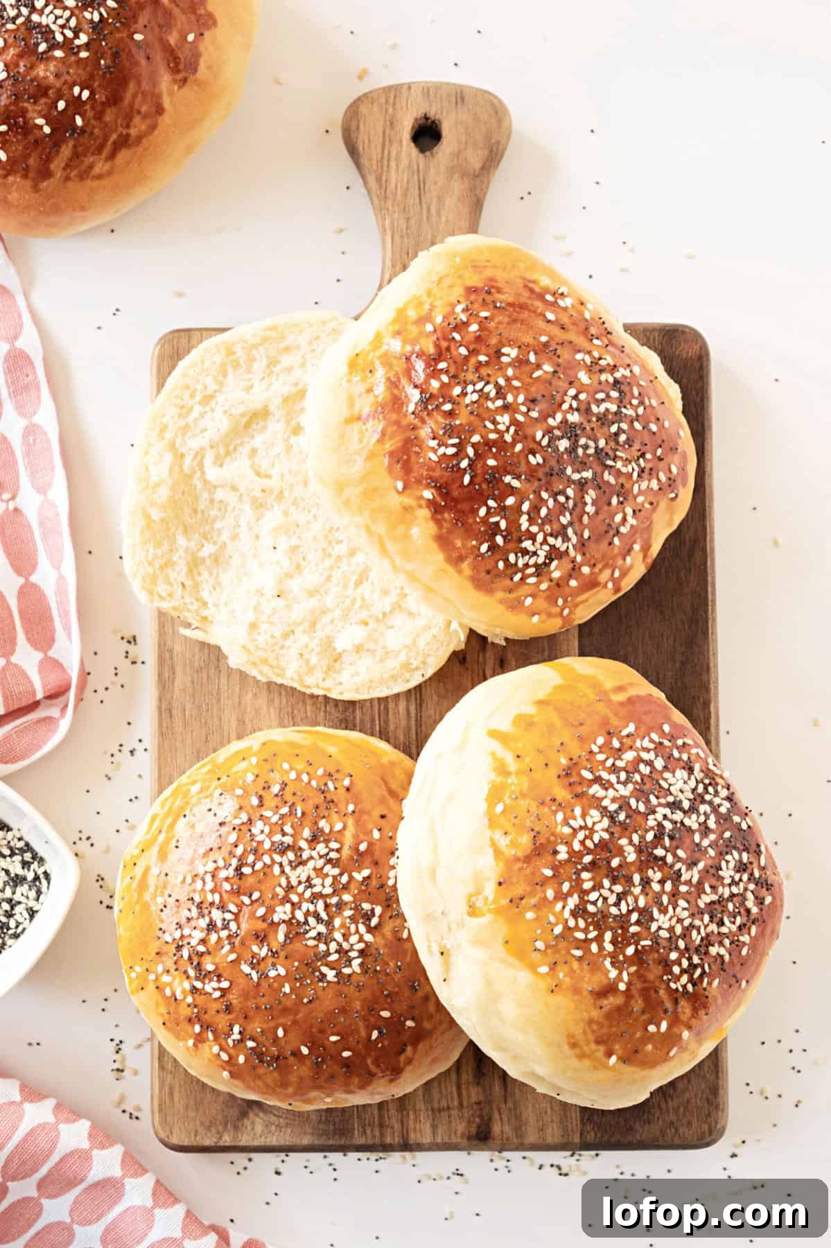 Perfectly Soft Homemade Burger Buns Recipe 2 Wooden board with hamburger buns with seeds. White surface.