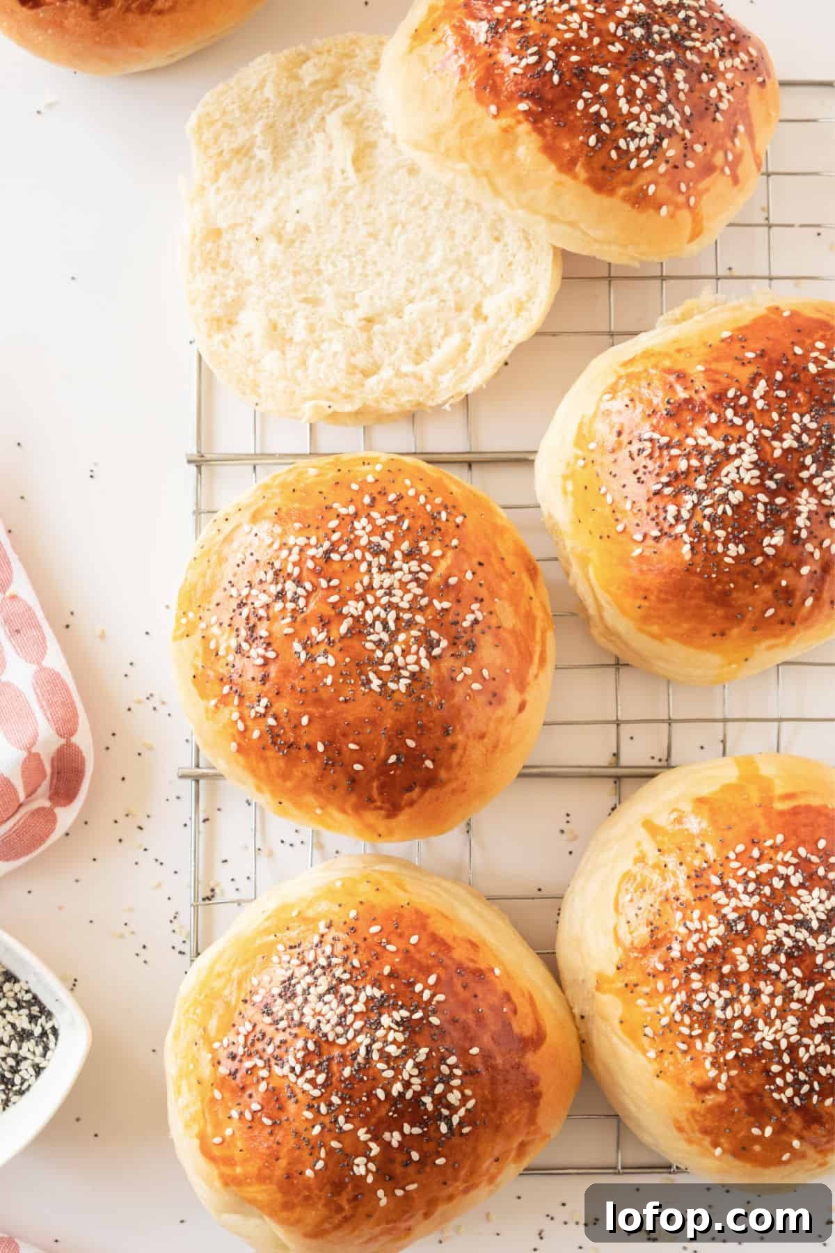 Perfectly Soft Homemade Burger Buns Recipe 4 Several burger buns on a wire rack. White surface.