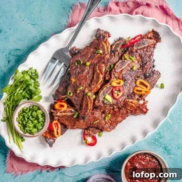 Flanken beef short ribs on a platter with green onion and sauce.