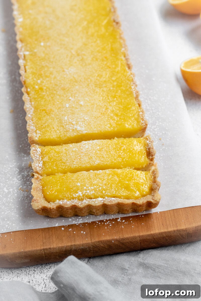 Meyer Lemon and Olive Oil Tart Recipe for Bright, Silky Dessert 5 A lemon tart cut into slices with a Meyer lemon.