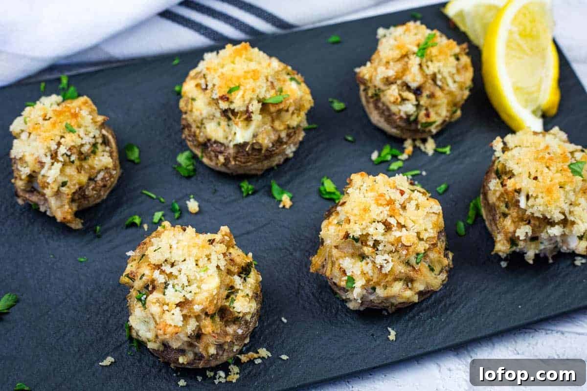 31 Irresistible Seafood Dinners to Add Fish to Your Weekly Menu 11 A slate platter with six crab stuffed mushrooms garnished with herbs.