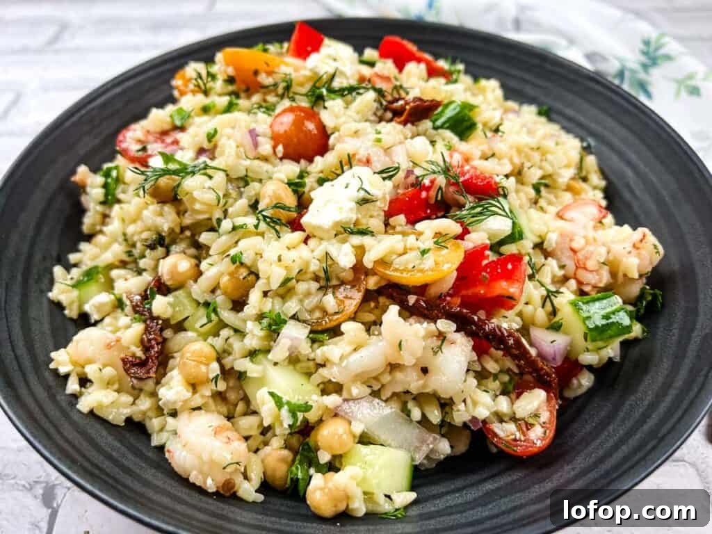 31 Irresistible Seafood Dinners to Add Fish to Your Weekly Menu 18 A bowl of Mediterranean orzo salad on a black plate.