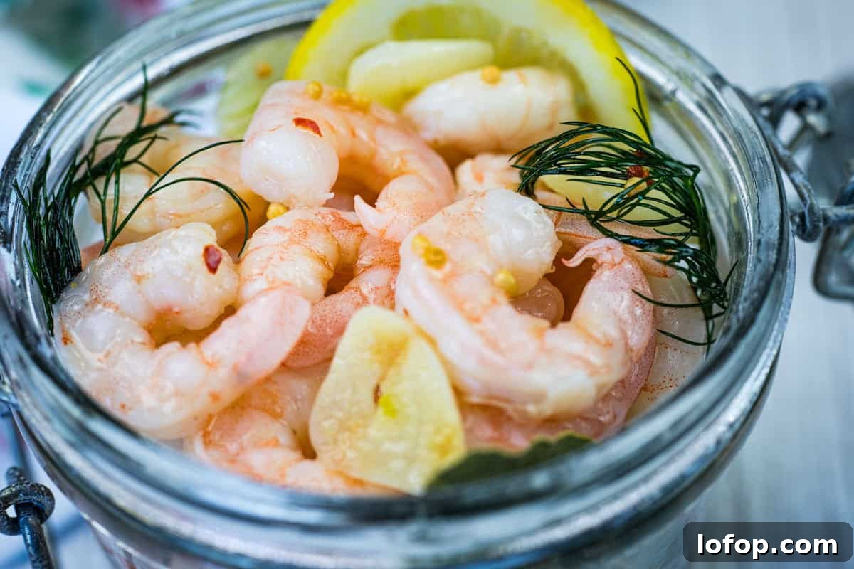 31 Irresistible Seafood Dinners to Add Fish to Your Weekly Menu 22 Close-up Southern Style Pickled Shrimp with lemon slices and dill on a jar.