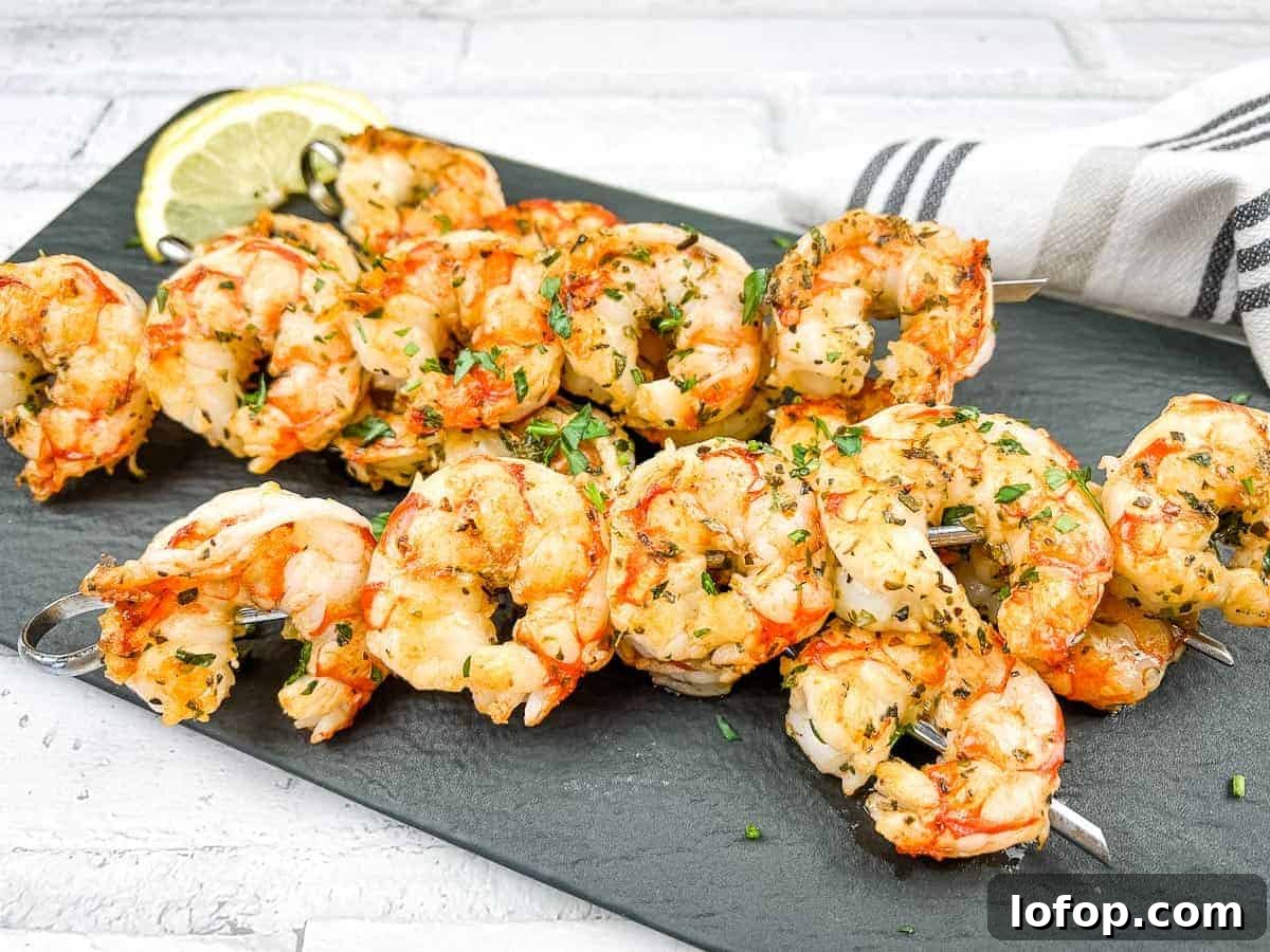 31 Irresistible Seafood Dinners to Add Fish to Your Weekly Menu 24 Shrimp skewers on a white plate with lemon wedges.