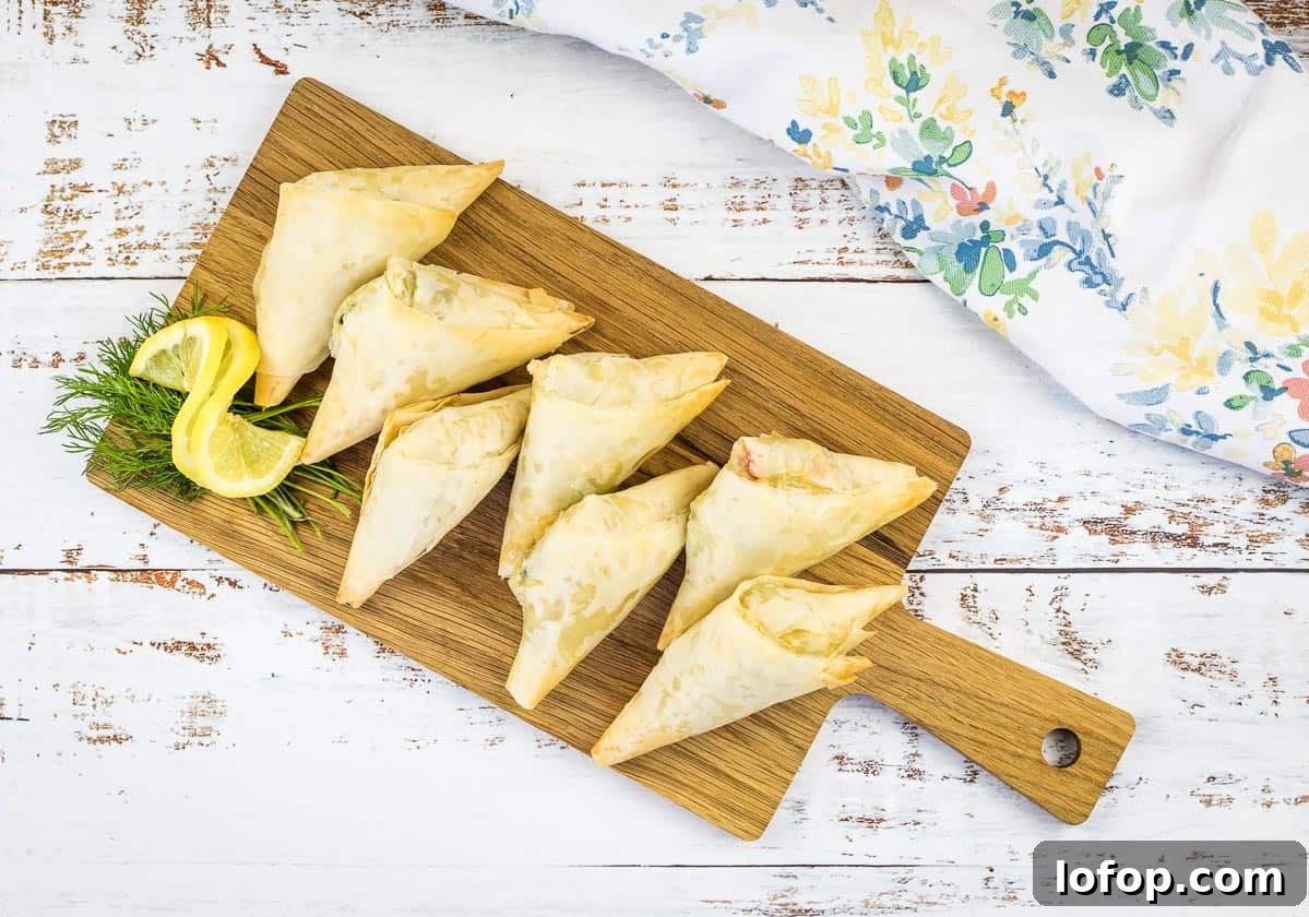 31 Irresistible Seafood Dinners to Add Fish to Your Weekly Menu 25 Crab Spanakopita triangles on a cutting board.
