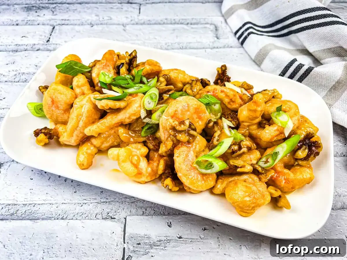 31 Irresistible Seafood Dinners to Add Fish to Your Weekly Menu 26 A plate of Copycat Panda Express Honey Walnut Shrimp served on a white rectangular dish.
