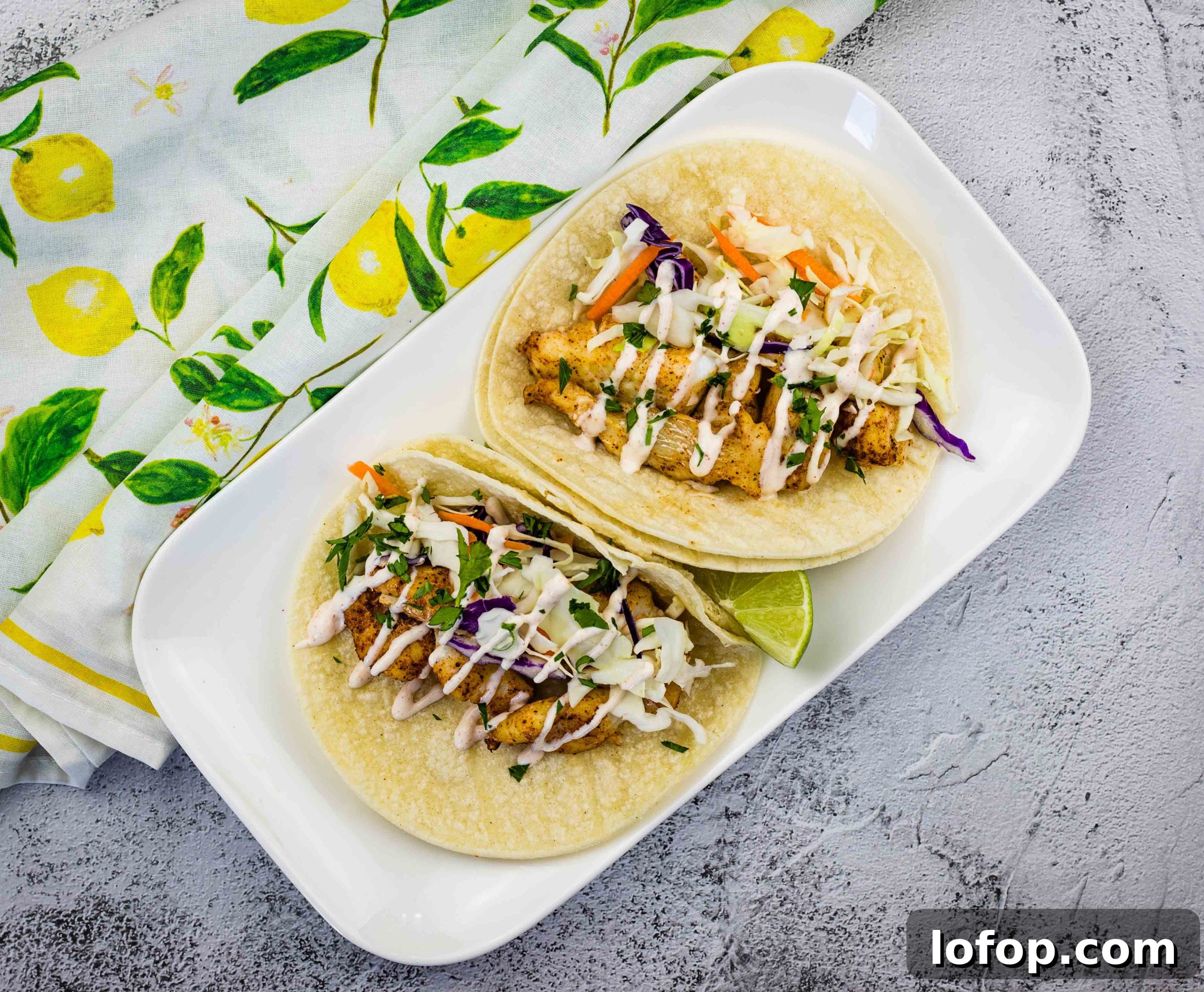 31 Irresistible Seafood Dinners to Add Fish to Your Weekly Menu 27 Baja fish tacos on a white plate.