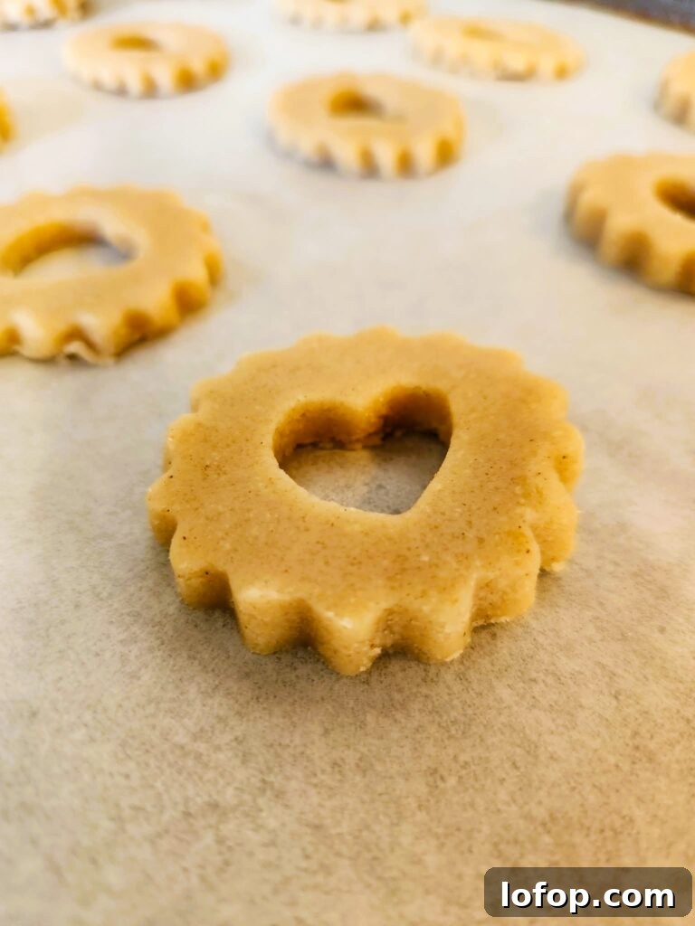 Baking Linzer sandwich cookies on a parchment-lined sheet tray.