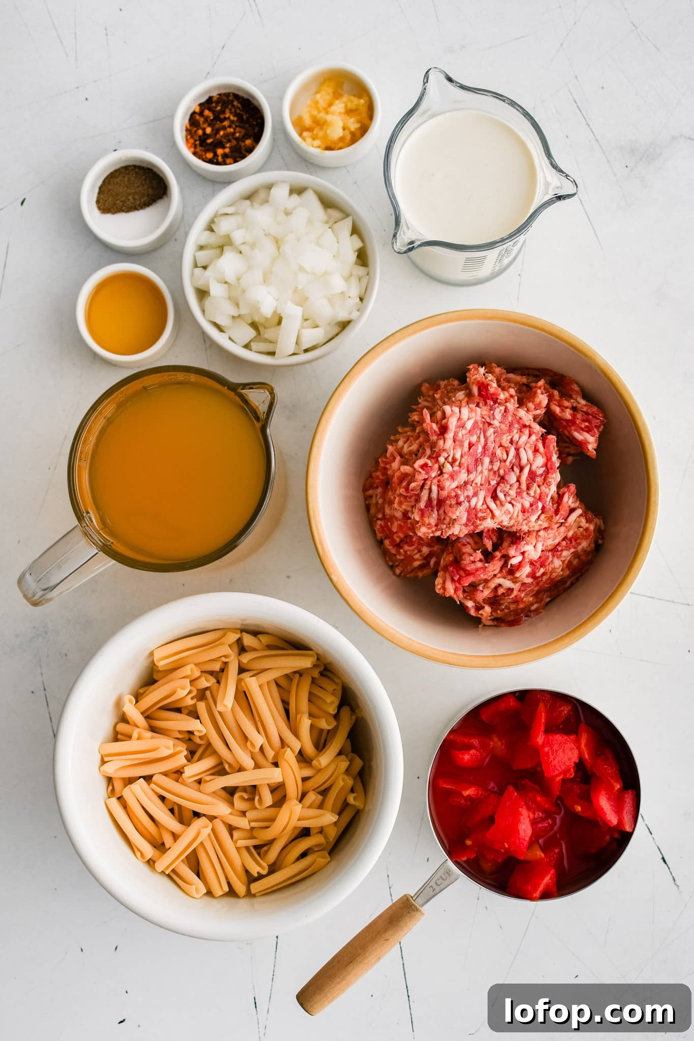 All of the ingredients for Italian sausage soup presented in individual measuring cups and ramekins.