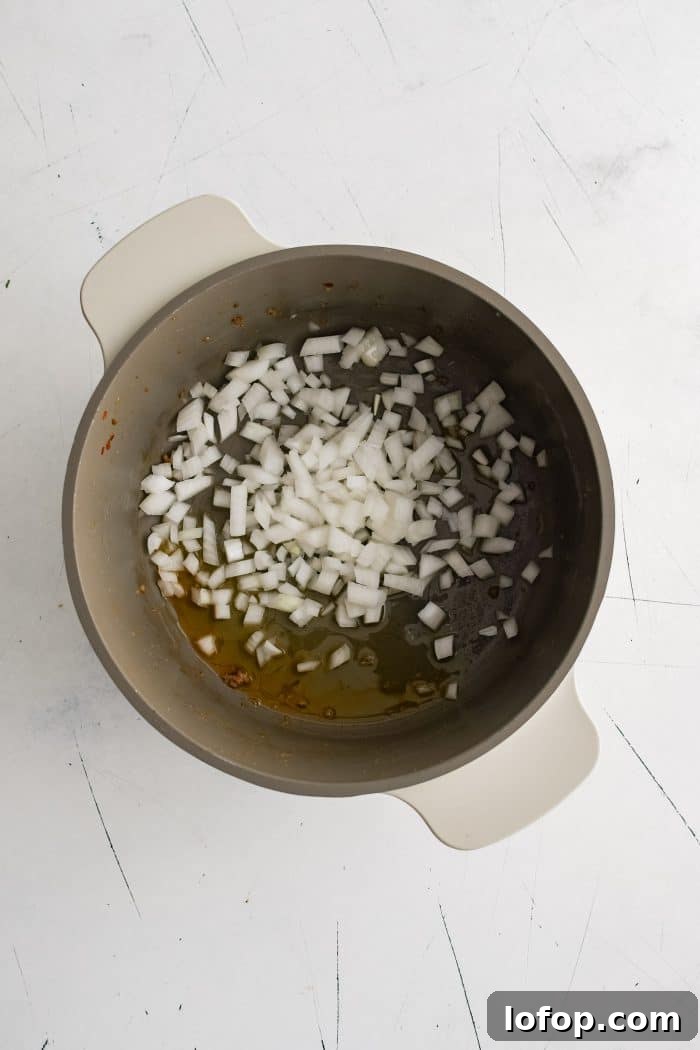 Large soup pot filled with diced raw white onion.