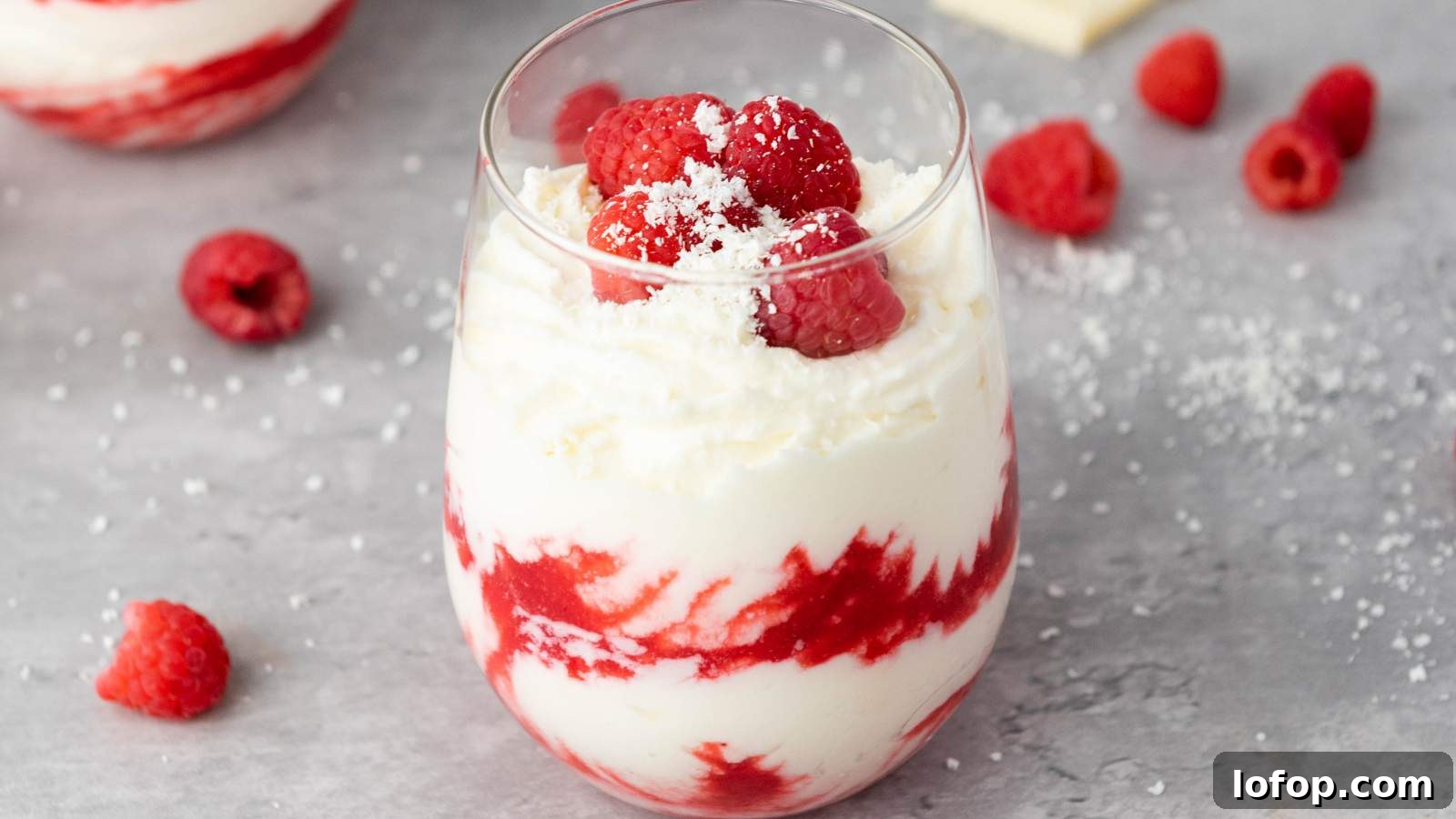 15 Decadent Low-Calorie Desserts That No One Will Suspect Are Light 10 A glass filled with white chocolate raspberry mousse, topped with fresh raspberries and a sprinkle of white shavings.