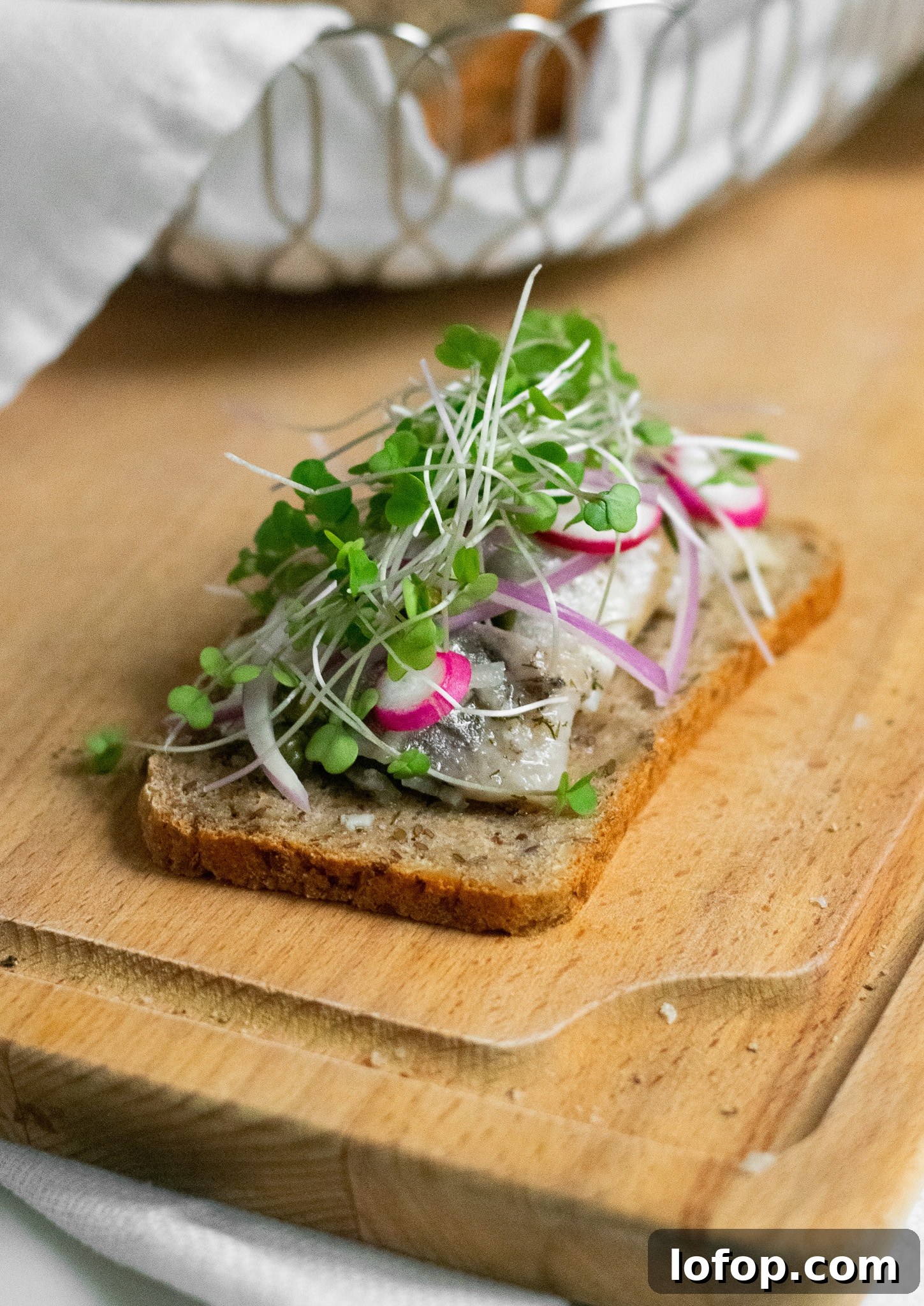 Smørrebrød: Traditional Danish Open-Faced Sandwich Recipes 31 A rye bread open faced sandwich topped with herring, onion, radish, and micro greens.