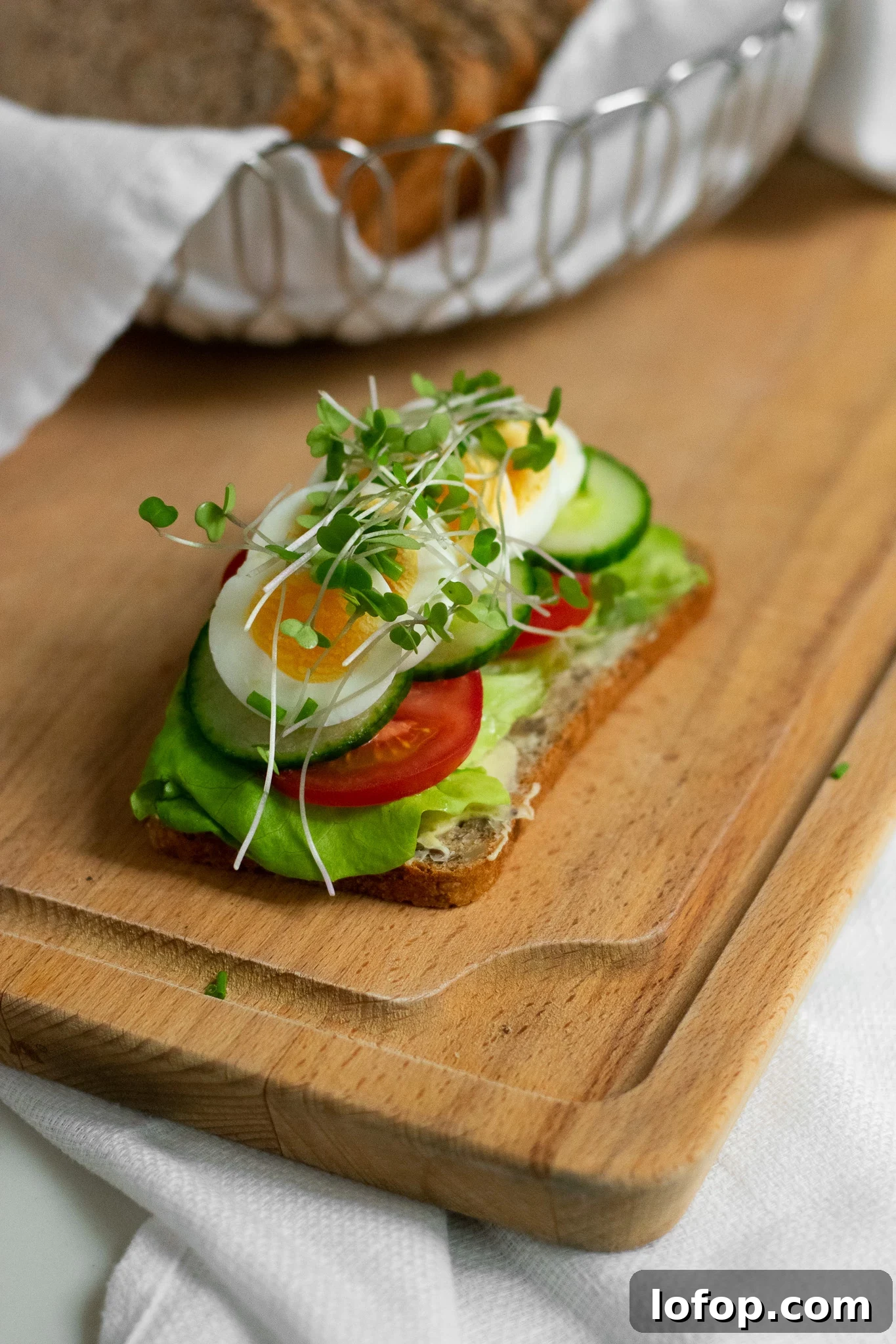 Smørrebrød: Traditional Danish Open-Faced Sandwich Recipes 36 A rye bread open faced sandwich topped with lettuce, tomato, cucumber, sliced egg, and micro greens.