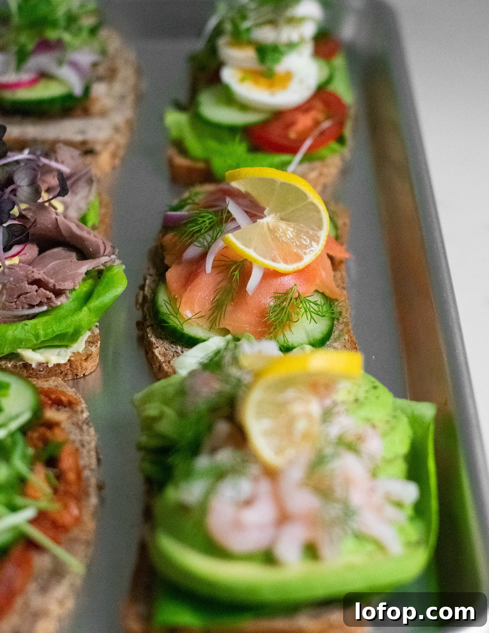 Smørrebrød: Traditional Danish Open-Faced Sandwich Recipes 7 Danish open faced sandwiches on a platter.