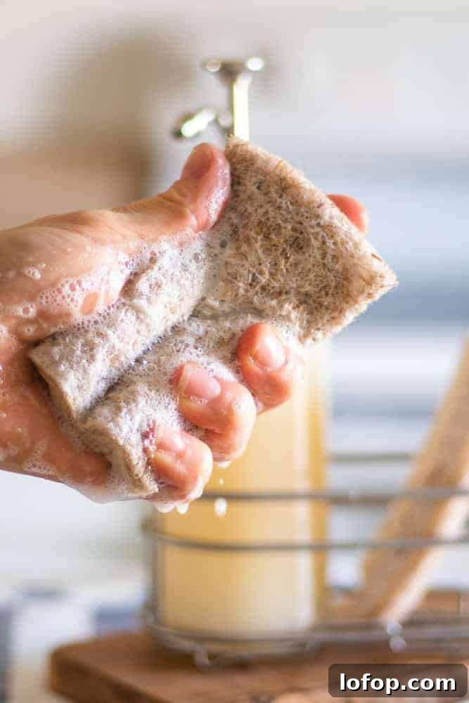 DIY Liquid Dish Soap Recipe for Sparkling Clean Dishes 5 sudsing up dish soap in in a sponge