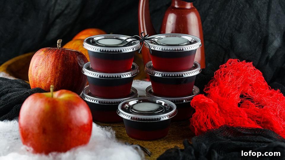 29 Jello Shot Recipes to Kick Off Any Party Night 12 A group of red apple jelly cups on a table.