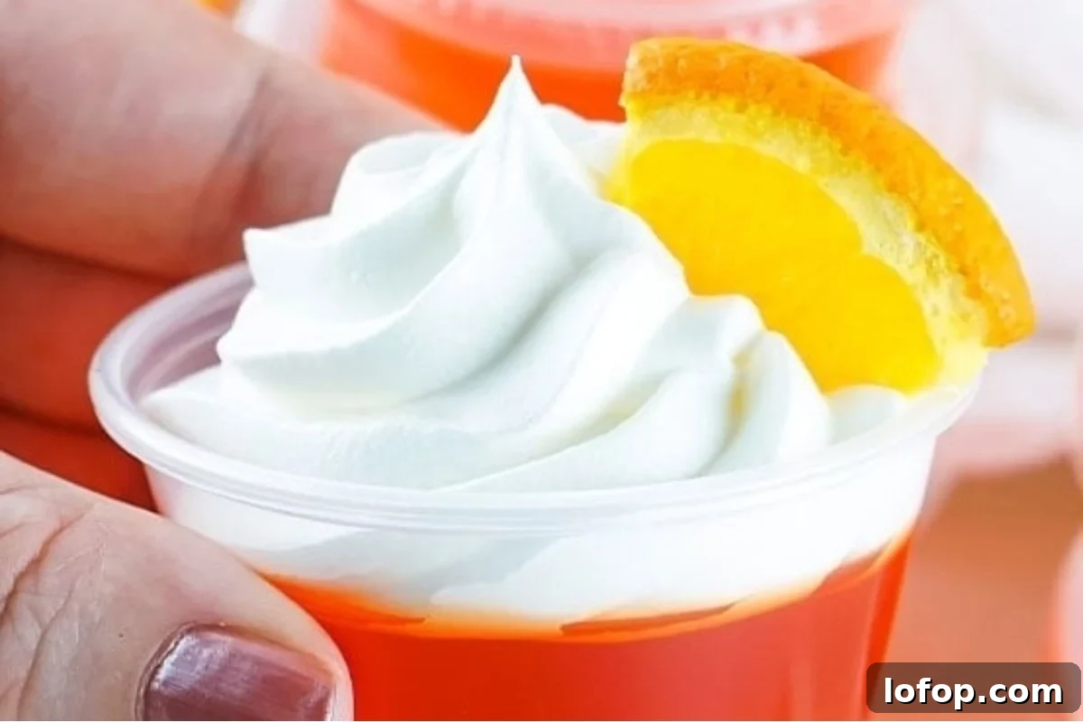 29 Jello Shot Recipes to Kick Off Any Party Night 13 A person holding a cup of orange juice with whipped cream at a New Year's eve party.
