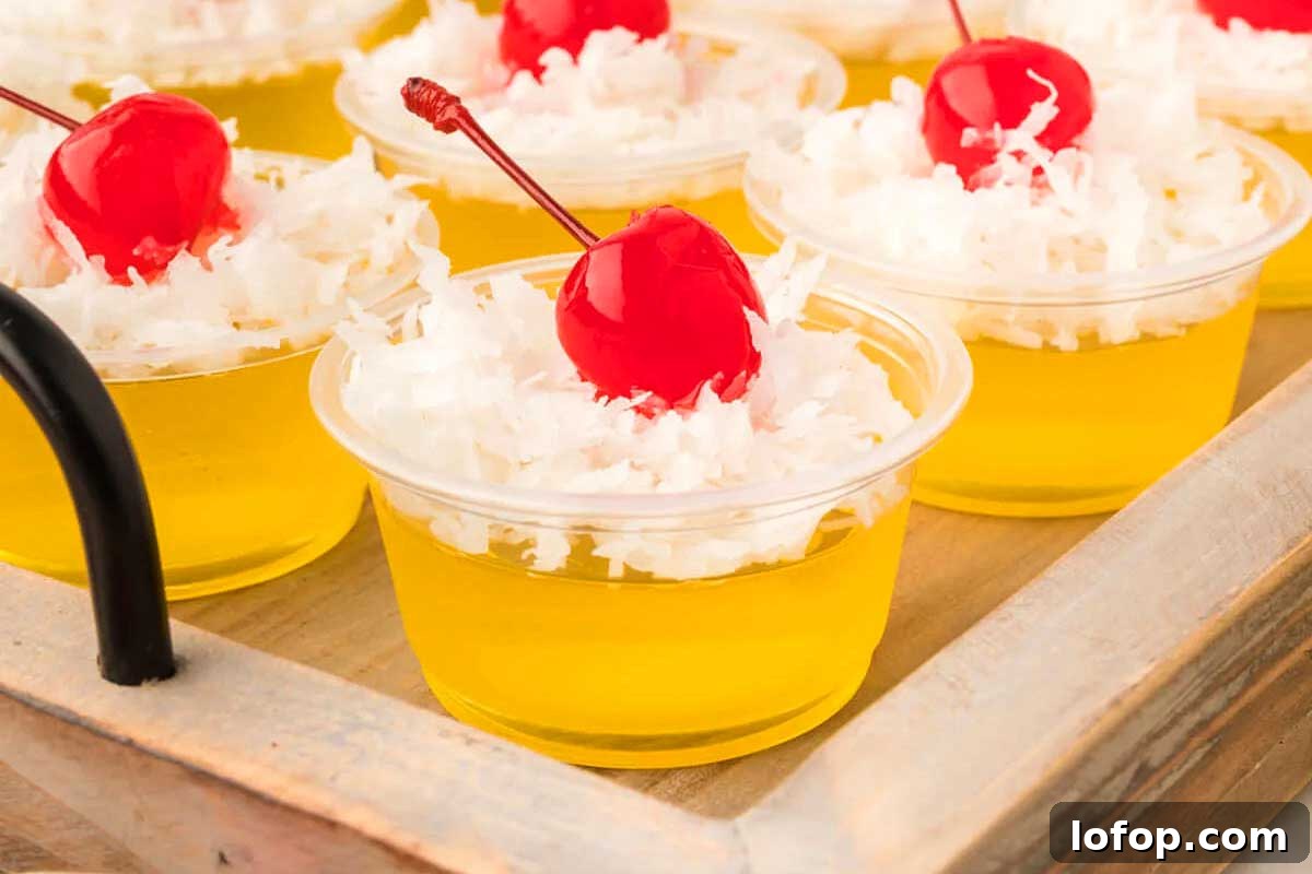 29 Jello Shot Recipes to Kick Off Any Party Night 20 A tray of small cups with whipped cream and a cherry on top, resembling jello shots.
