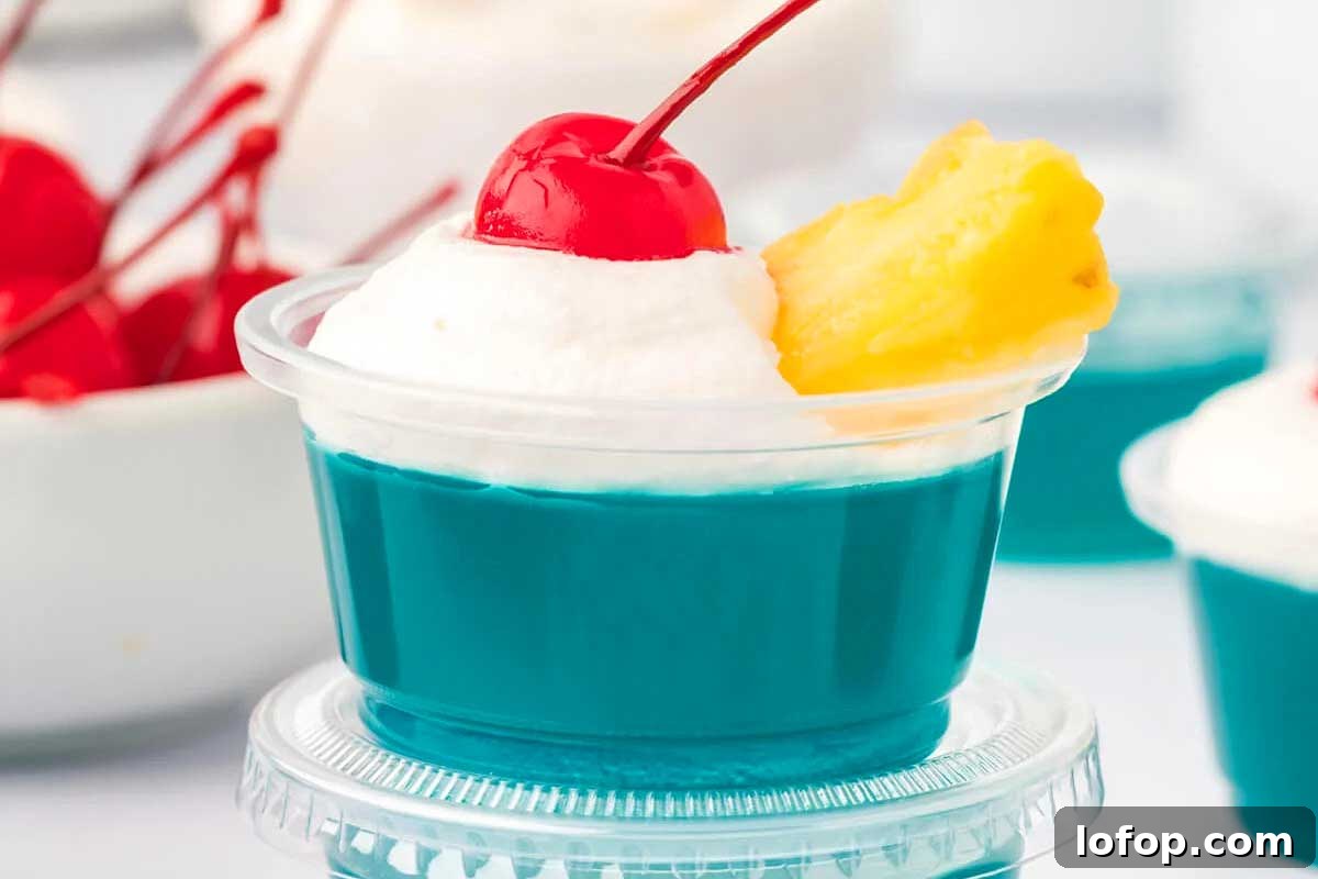 29 Jello Shot Recipes to Kick Off Any Party Night 23 A blue and white dessert with whipped cream and a cherry on top, perfect for jello shots.