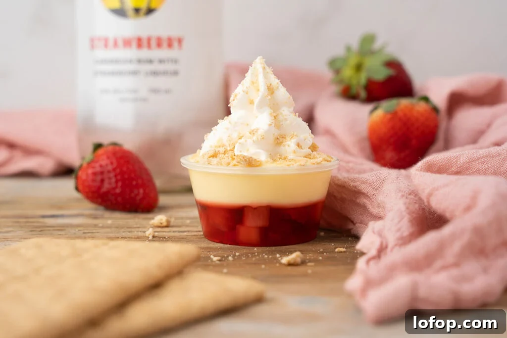 A cup of strawberry ice cream with [strawberry dessert cocktail] crackers next to a bottle of bourbon.