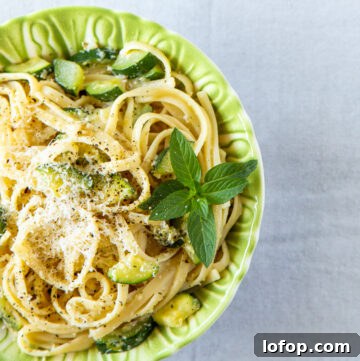 Bowl of zucchini and mint pasta garnished with mint.