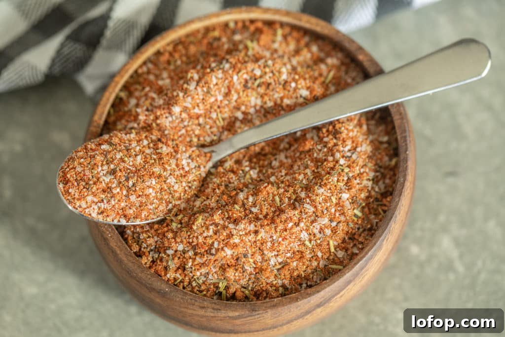 Spoonful of smoked turkey rub over a wooden bowl of smoked turkey rub.