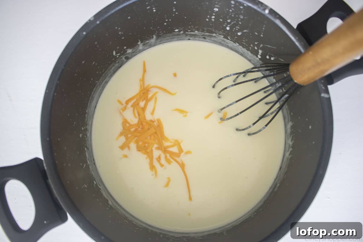 Slowly adding cheese to roux mixture.
