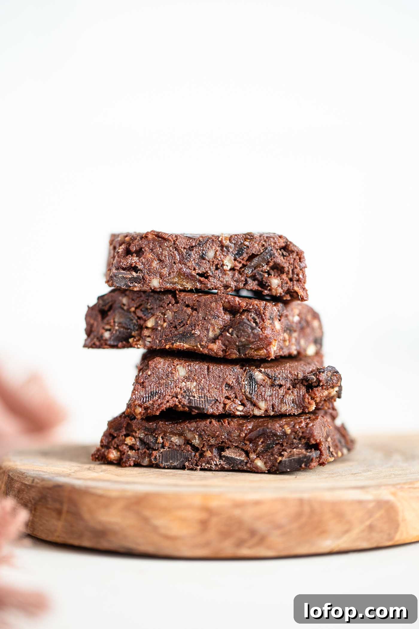 Vegan No-Bake Chocolate Brownies — Quick Raw Dessert Recipe 2 A stack of 4 raw brownies on a cutting board.