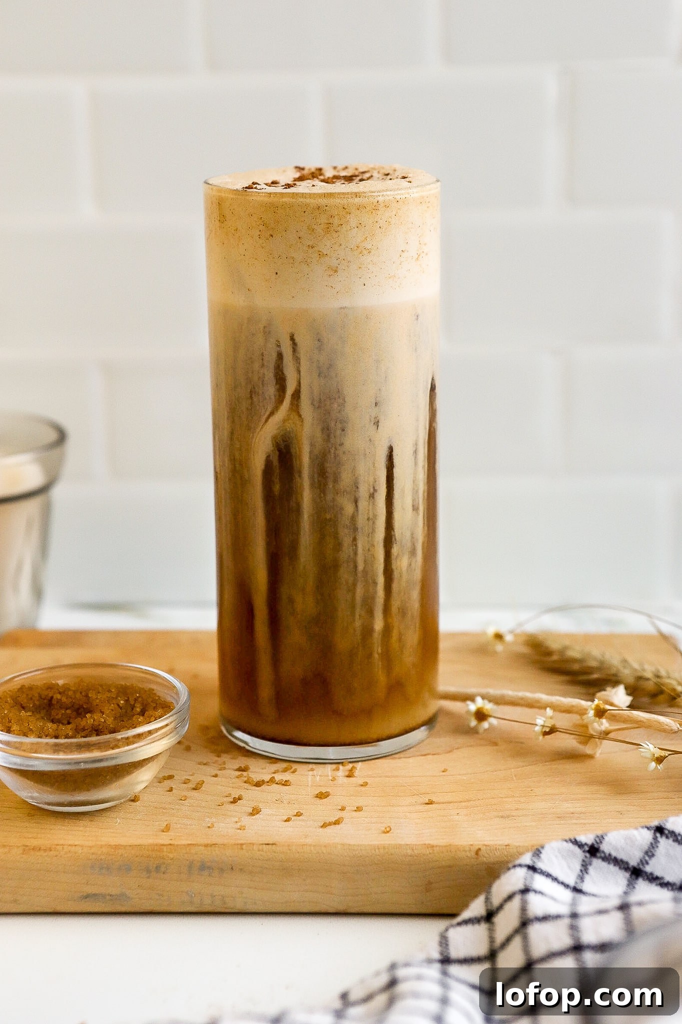 Starbucks Pumpkin Cream Cold Foam Recipe (Copycat) 6 close up shot of pumpkin cream cold foam with cold brew on brown cutting board in white kitchen