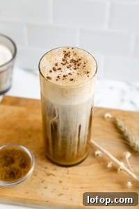 side view of cold coffee in glass with pumpkin spice topping and cinnamon